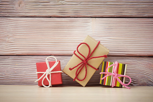 Gift boxes over light wooden background Fotolia
