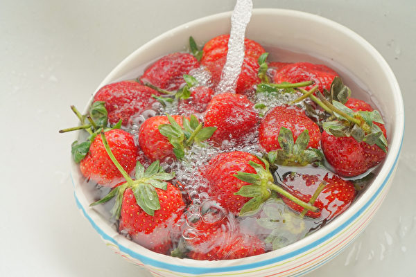 清洗草莓时，先不要去蒂头，并用流动的清水洗去农药。(Shutterstock)