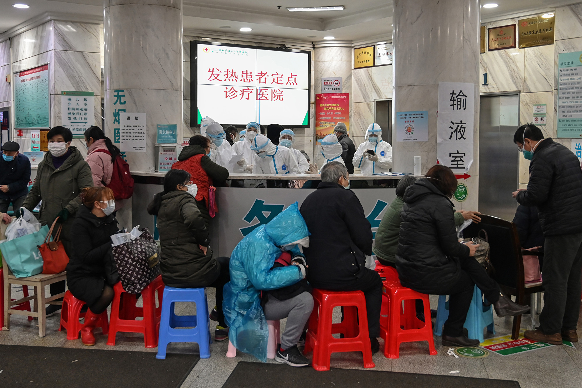 中共官方公布的確診及死亡人數與1,100萬人口的武漢為此封城不成比例。湖北航天醫院醫師胡電波表示匯總後統計發燒人群為10萬人。圖為1月24日武漢市武漢市紅十字會醫院人滿為患。(Photo by Hector RETAMAL / AFP)