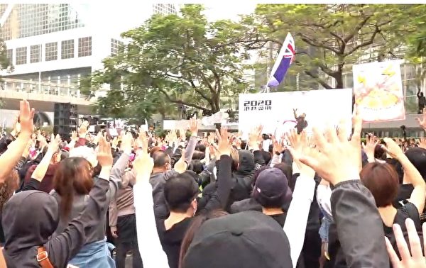 1月19日，港人舉行流水式集會，現場齊唱《願榮光歸香港》，並伸出五手指，表示五大訴求。（大紀元視頻截圖）