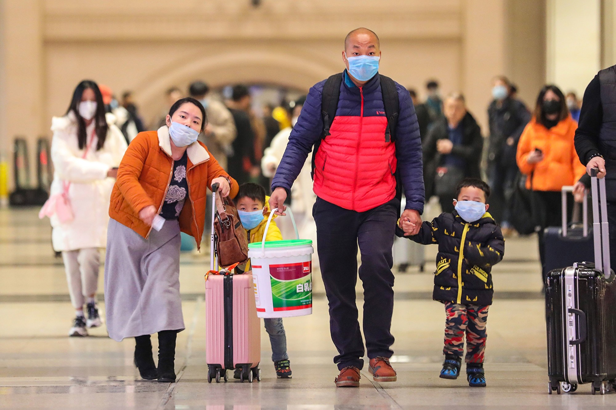 在媒体广泛报导中共病毒已杀到身边后,武汉市民如梦初醒,急忙戴口罩防备。图为1月21日武汉汉口火车站,乘客戴上口罩。(China OUT / AFP)