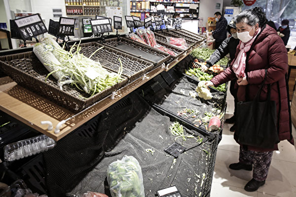  武漢市民戴口罩到超市買菜，貨架上的菜被一掃而光。（Photo by Getty Images）