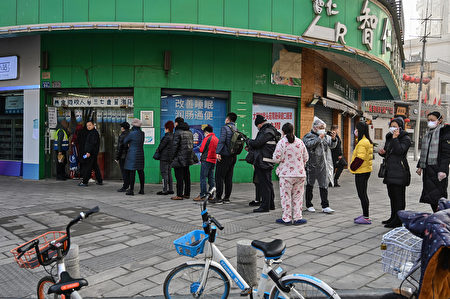 2020年1月30日，人們戴著口罩在湖北省武漢市的一個藥店前排隊。（Photo by Hector RETAMAL/AFP）