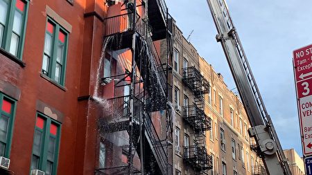 大火次日上午，消防局的水槍還在一陣一陣的向樓中噴射水龍。