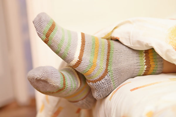 夜晚穿襪子睡覺能降低核心體溫，有助睡眠。(Shutterstock)
