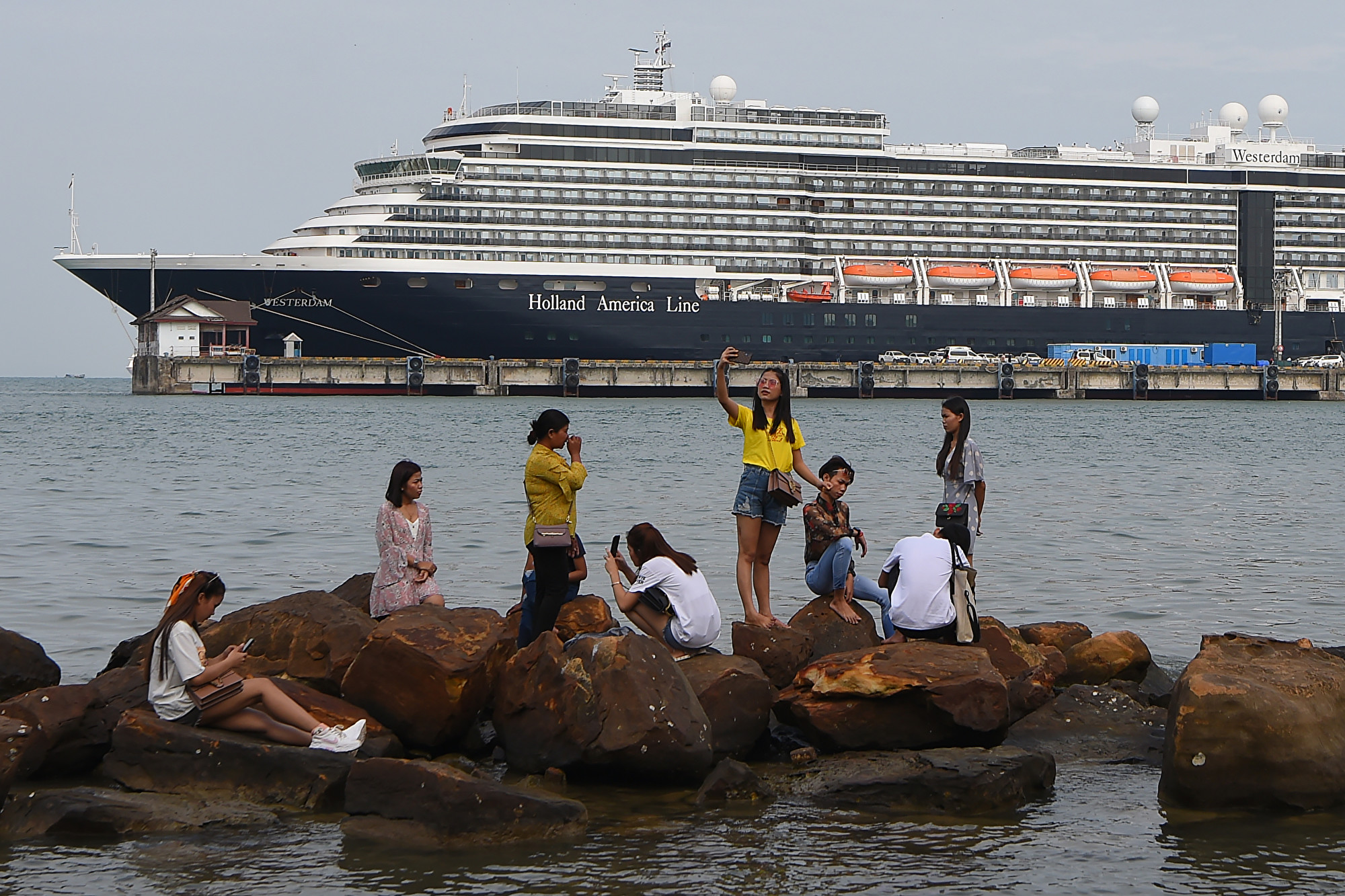 “威士特丹号”邮轮(Westerdam)13日获准在柬埔寨停靠后,传出一名83岁美籍女士下船乘飞机转抵马来西亚后确诊染武汉肺炎。图为2月18日仍停靠在柬埔寨的威斯特丹邮轮。(TANG CHHIN Sothy/AFP)