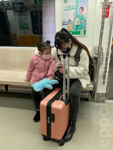 2月29日，北京地鐵空空盪盪，幾乎無人乘坐。圖為一女子帶著孩子坐地鐵。（大紀元）