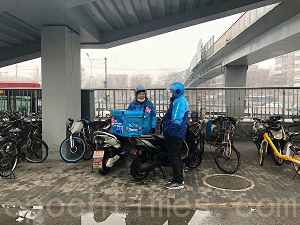 2月29日，北京不少地區管控升級，街上有快遞小哥送貨。（大紀元）