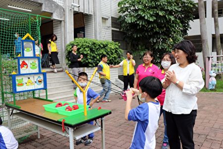 市长黄敏惠与学生玩愤怒鸟游戏。