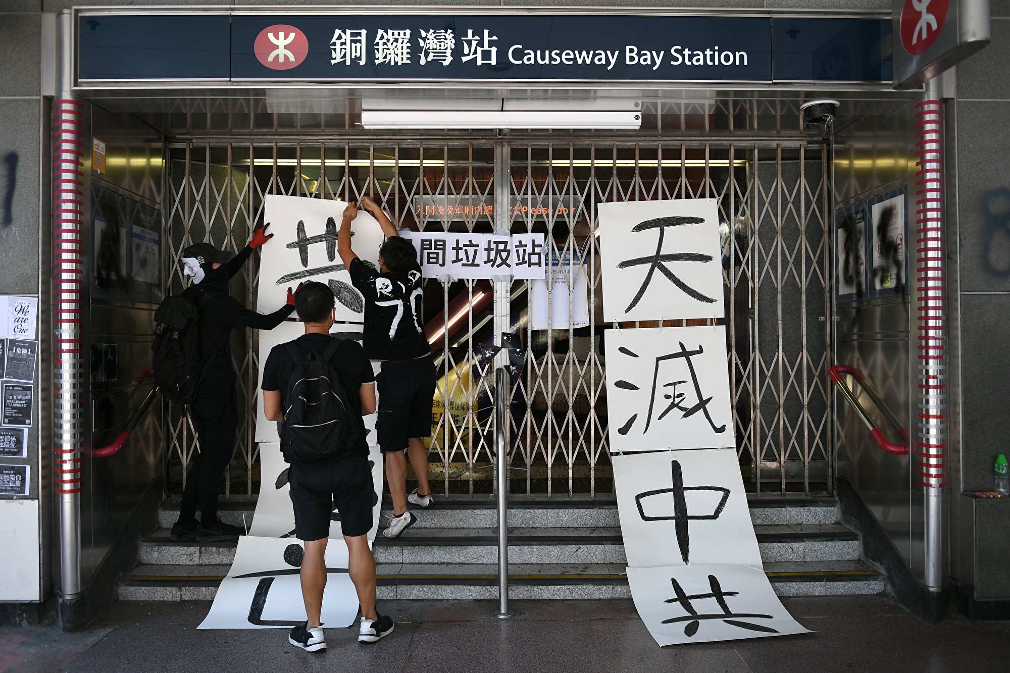 香港街頭標語「天滅中共」令中共極度恐懼。圖為10月1日香港「沒有國慶 只有國殤」遊行,有抗爭者在關閉的銅鑼灣地鐵站口布置標語牌「天滅中共」。(Mohd RASFAN/AFP)
