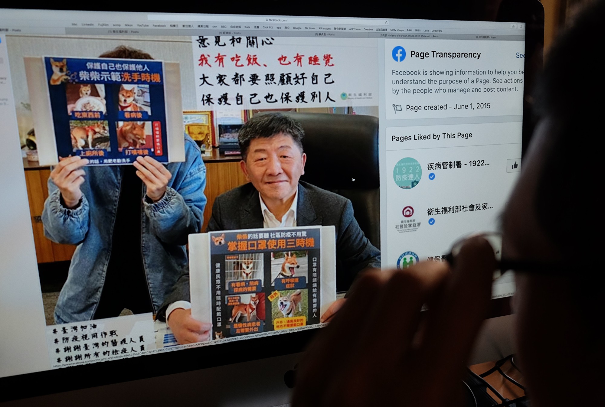 台灣疫情指揮中心指揮官、衛福部長陳時中舉著標語牌,宣傳預防COVID-19的方法。(SAM YEH/Getty Images)