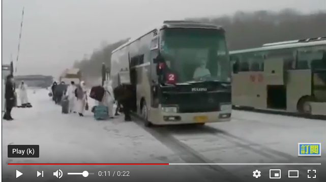 从俄罗斯入境的华人在大雪纷飞中,被从俄方客车转运到中方客车,中共派遣了武警部队。(视频截图)