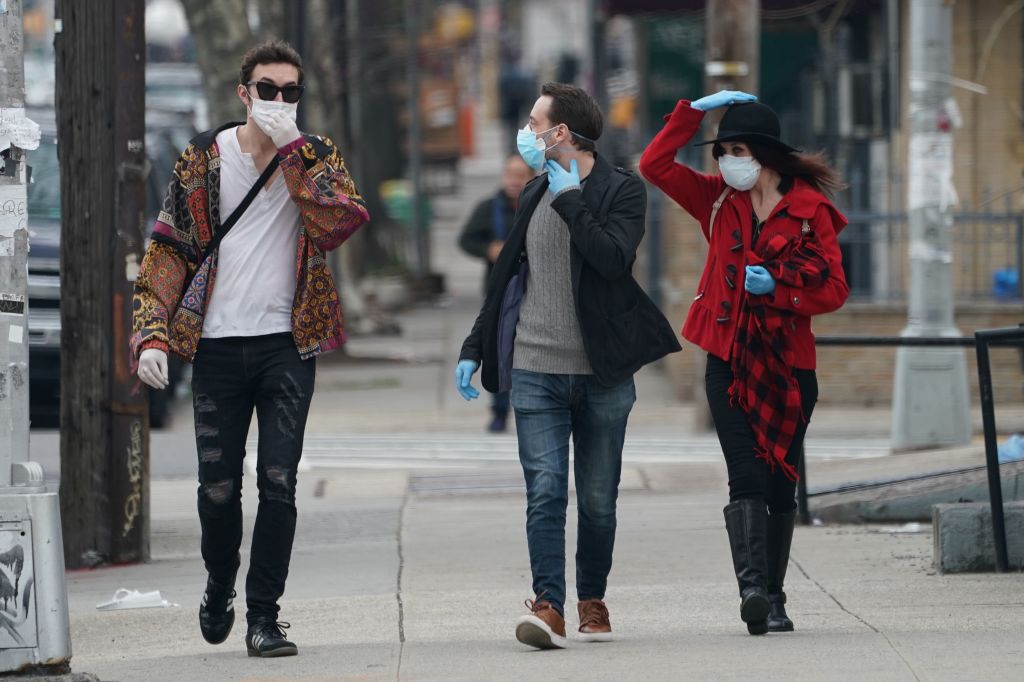 人們戴著口罩及塑料手套在紐約布碌崙Bushwick區漫步。(BRYAN R. SMITH/AFP via Getty Images)