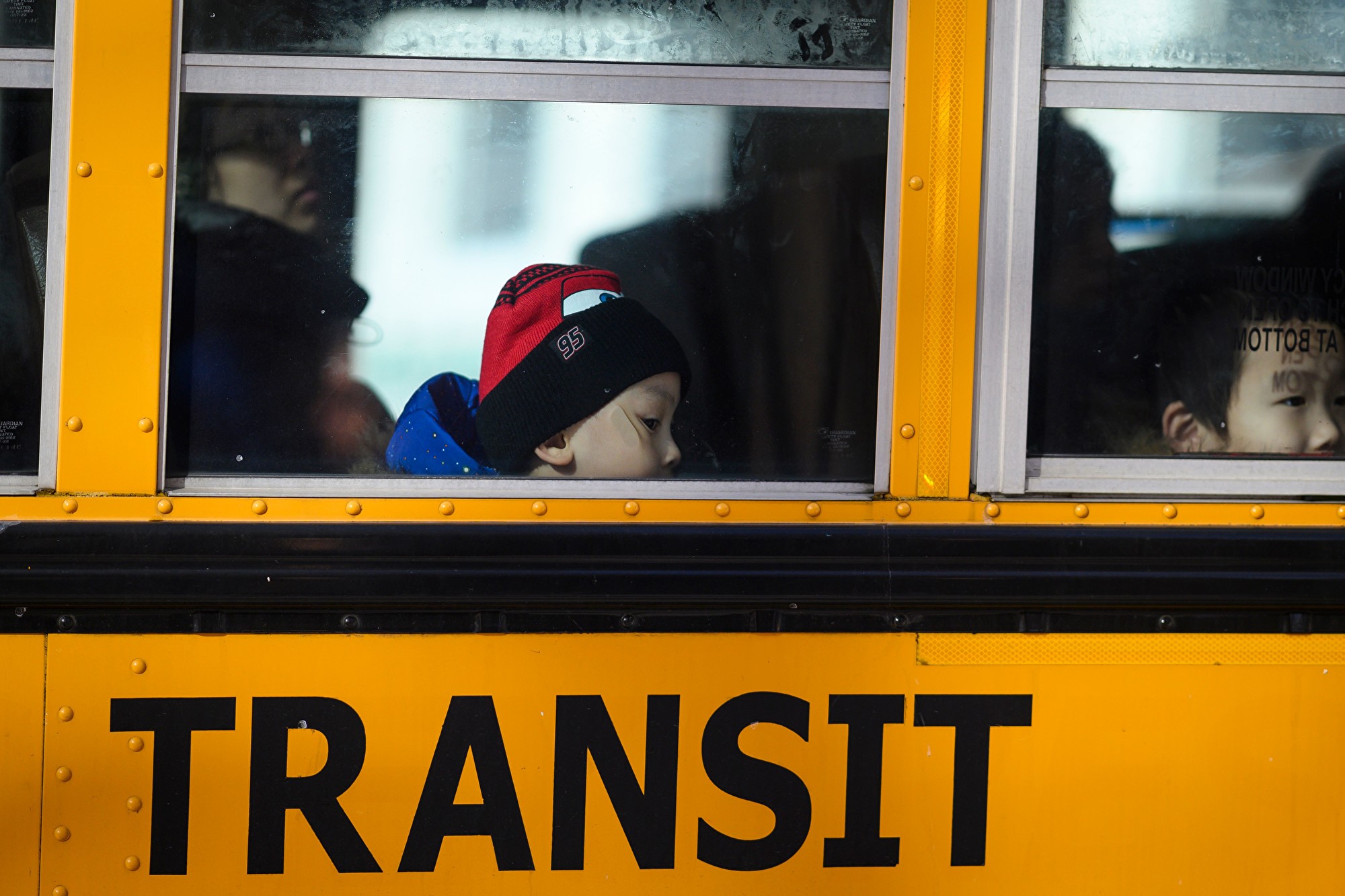 圖為2019年1月30日,在紐約市,一名男孩靠坐在校車窗邊。(JOHANNES EISELE/AFP via Getty Images)