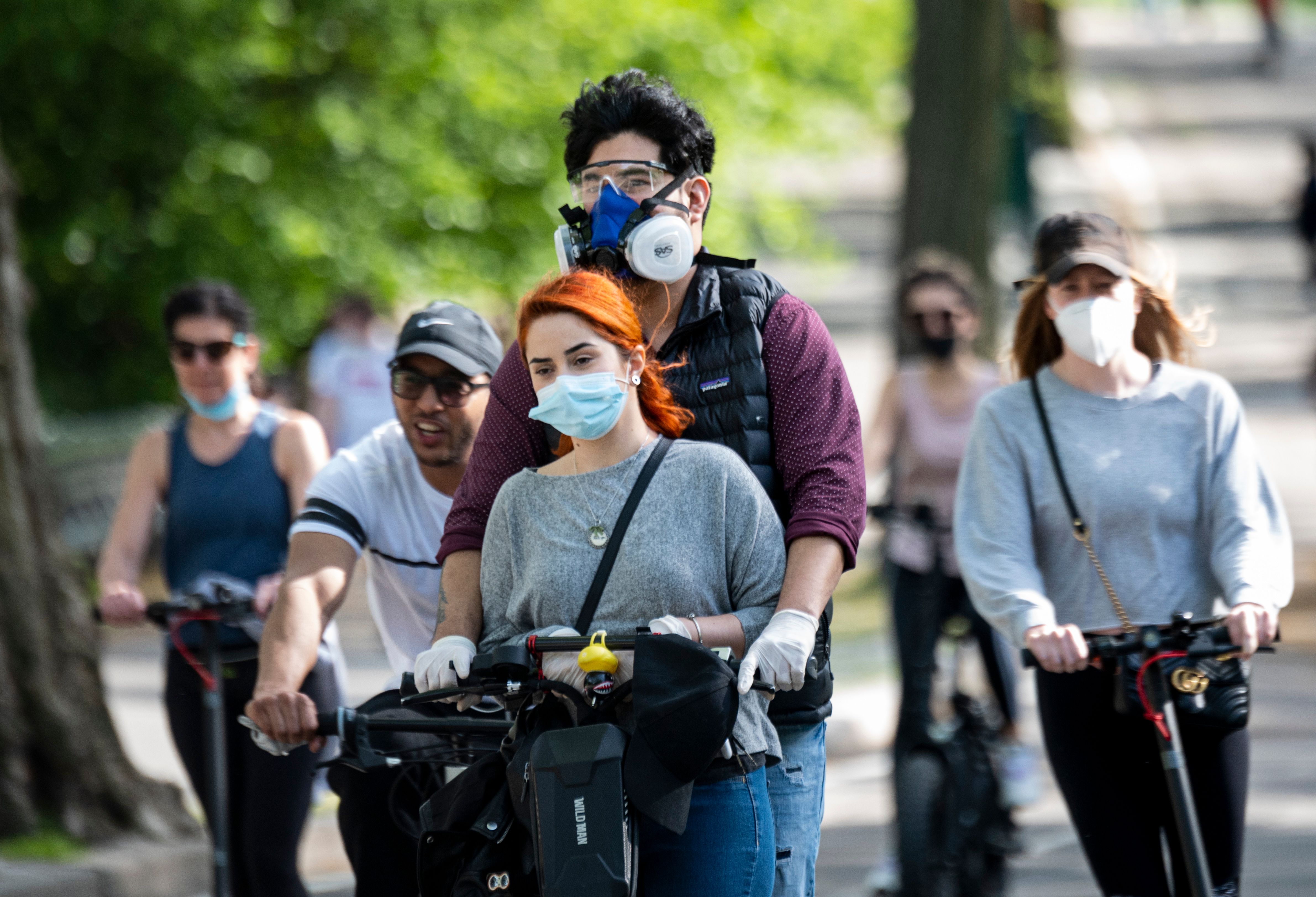 在病毒大流行期間,紐約人戴著口罩在中央公園騎電動滑板車。(JOHANNES EISELE/AFP via Getty Images)