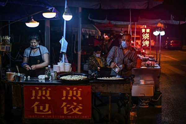 擔心失業造成社會恐慌，被打壓15年的「地攤經濟」再度被啟用，圖為武漢一賣煎包的地攤。（HECTOR RETAMAL/AFP via Getty Images）