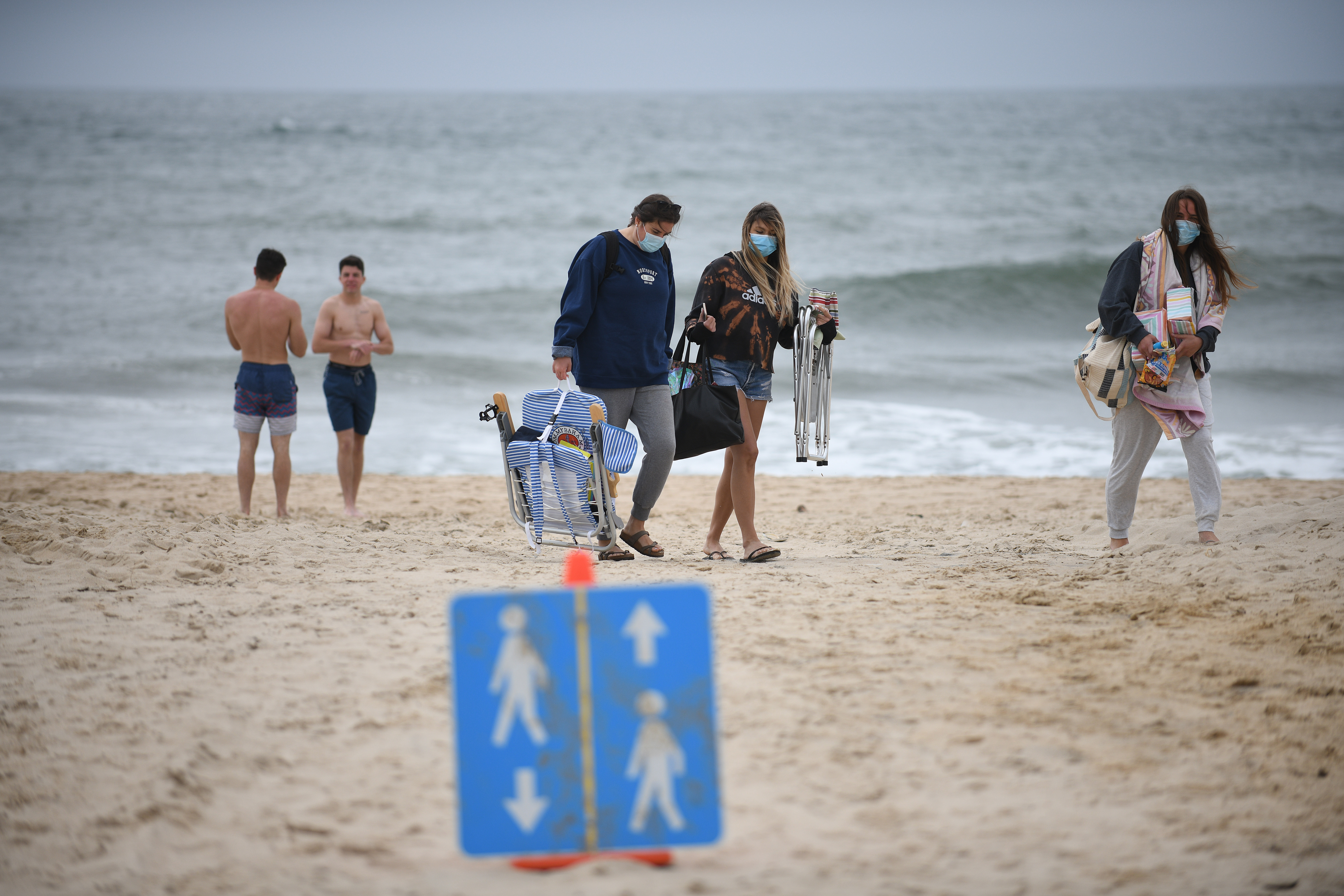 圖為紐約人戴著口罩在陣亡將士紀念日週末到海灘上散步。(Astrid Riecken/Getty Images)