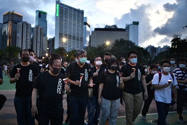 6月4日，香港市民抵达维园，并举起蜡烛悼念“六四”受难者。图中有支联会主席李卓人等人。（ANTHONY WALLACE/AFP via Getty Images）