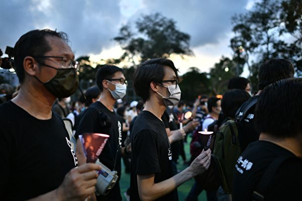 6月4日，香港市民抵达维园，并举起蜡烛悼念“六四”受难者。（ANTHONY WALLACE/AFP via Getty Images）