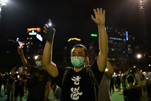 6月4日，香港市民在維園足球場悼念「六四」受難者。一參與者打開手機自帶燈，並伸出五個手指。（ANTHONY WALLACE/AFP via Getty Images）