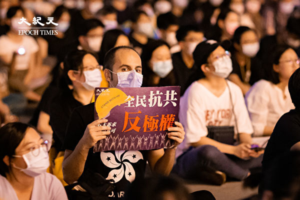 六四天安門事件31周年，「遍地燭光悼六四」活動6月4日晚間在台北中正紀念堂自由廣場前舉辦，參與民眾手舉「全民抗共反極權」看板。（陳柏州／大紀元）