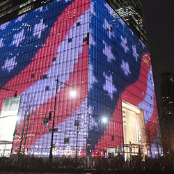 圖為紐約市世貿中心被紅、白、藍三色燈裝點，呈現美國國旗圖案。