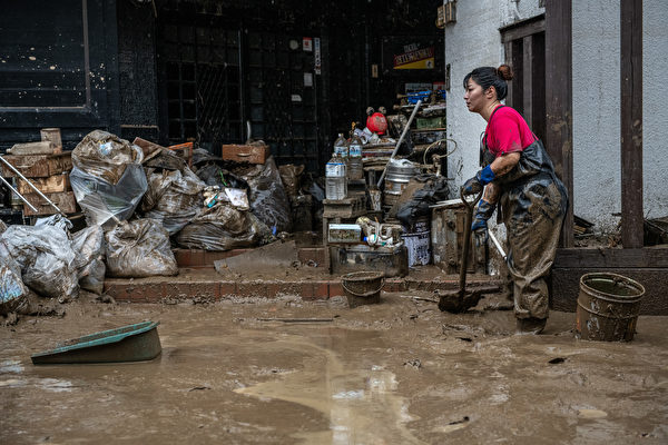 日本熊本縣周六（7月4日）降暴雨導致洪災和山泥傾瀉，造成至少20人死亡，14人失蹤。圖為2020年7月5日，日本熊本縣人吉市的一名婦女在清除球磨川決堤後衝進房屋裏的污泥。（Carl Court/Getty Images）