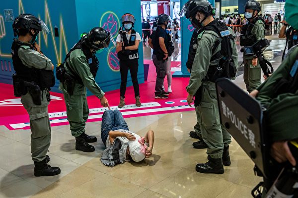 2020年7月6日，香港，購物中心地上躺著一位抗議的市民，幾位防暴警察圍著她。（ISAAC LAWRENCE/AFP via Getty Images）