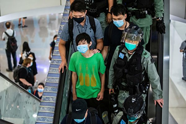 2020年7月6日，香港，購物中心警察帶走一位抗議的男子（穿綠衣者）。（ISAAC LAWRENCE/AFP via Getty Images）