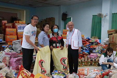 雲林家扶主委陳燦勳（右一）主任廖志文（左一）也一起幫忙裝袋供品，準備分送給受助家庭 。