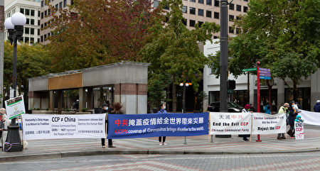 10月18日，西雅圖部份法輪功學員在西雅圖市中心，舉行了「終結中共」的活動。圖為法輪功學員在街旁手持真相橫幅，並向路人徵簽。（Jason Wang／大紀元）