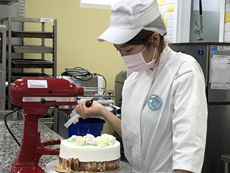 光華高中顏佳玲參加「開元鮮奶油蛋糕組」烘焙類，講究技巧、創意藝術、色彩、擠花、整體造型、衛生，她仔細的調製蛋糕。