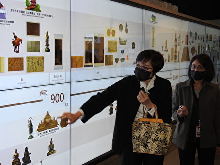 故宫南院科长于秉仪（左），为来宾导览解说数位“亚洲艺术互动年表”展出。