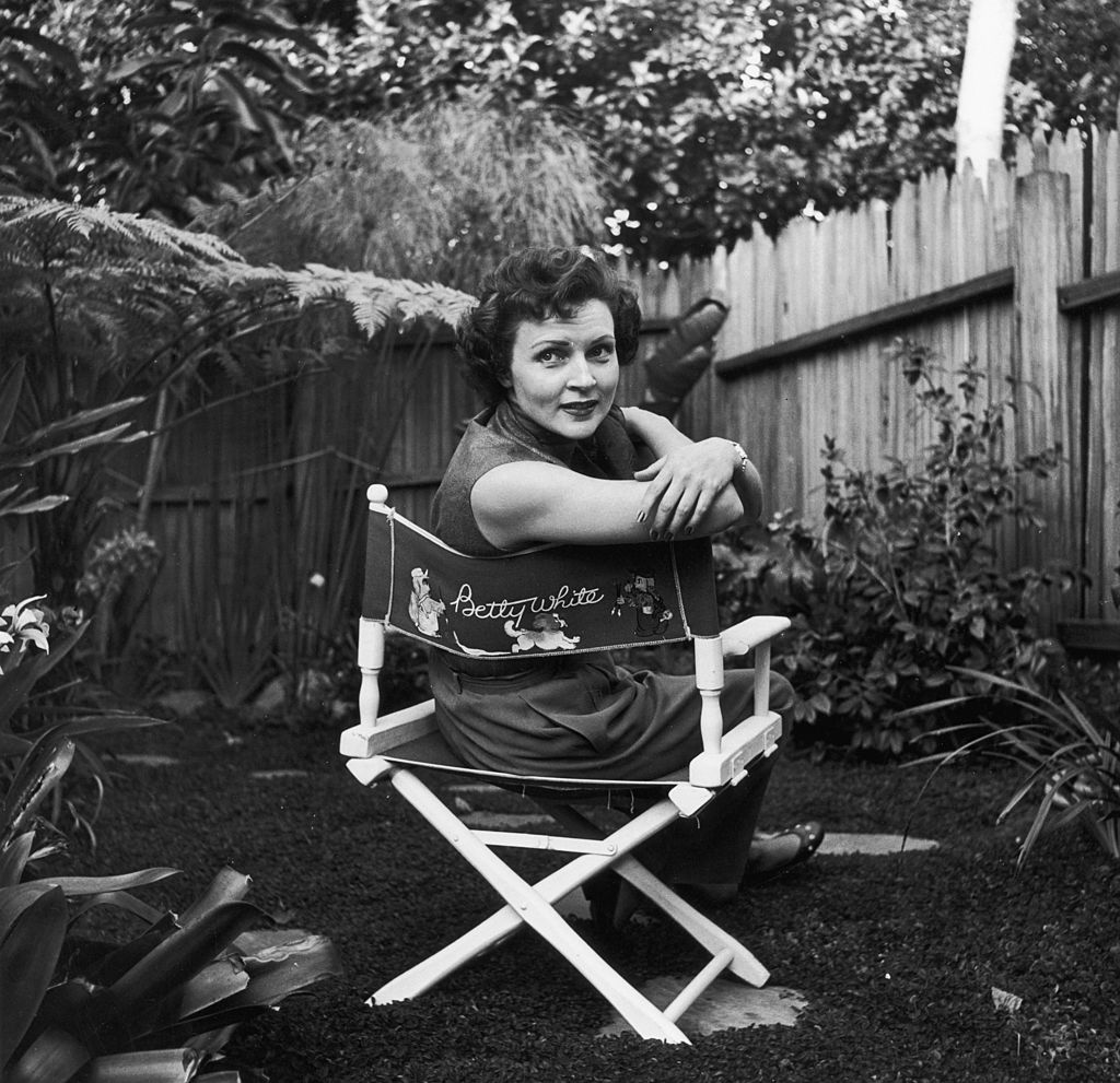 貝蒂·懷特(Betty White)大約在1956年坐在帆布椅上,她的名字裝飾在椅子的背面。(Hulton Archive/Getty Images)