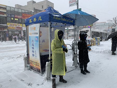 法輪功學員頂風冒雪，堅持每天向過往的民眾傳遞法輪大法好的福音。