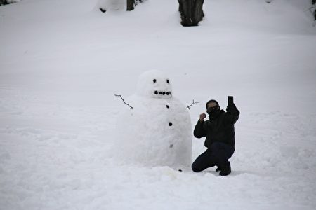 纽约民众在中央公园与雪人自拍。
