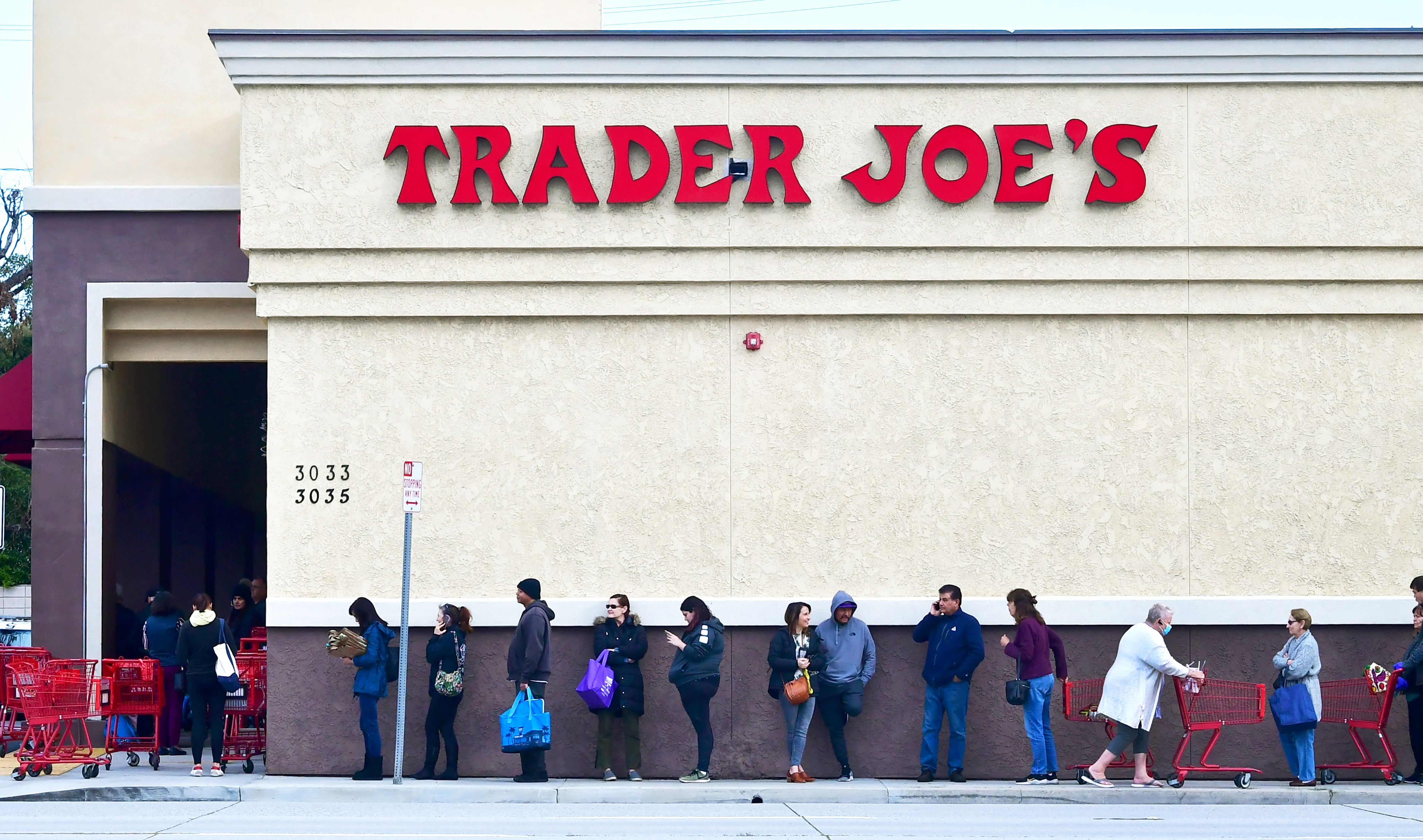 圖為2020年3月18日,在洛杉磯帕薩迪納的喬氏超市(Trader Joe's)店開始營業前,人們在排隊等候購物。(FREDERIC J. BROWN/AFP via Getty Images)