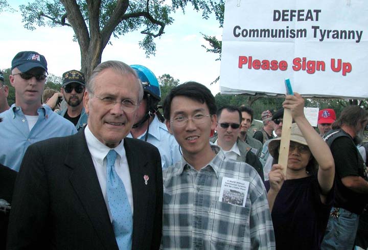 2005年5月29日美國防部長拉姆斯菲爾德（Donald H. Rumsfeld）和林肯紀念館附近的退黨徵簽中心義工合影。（大紀元）