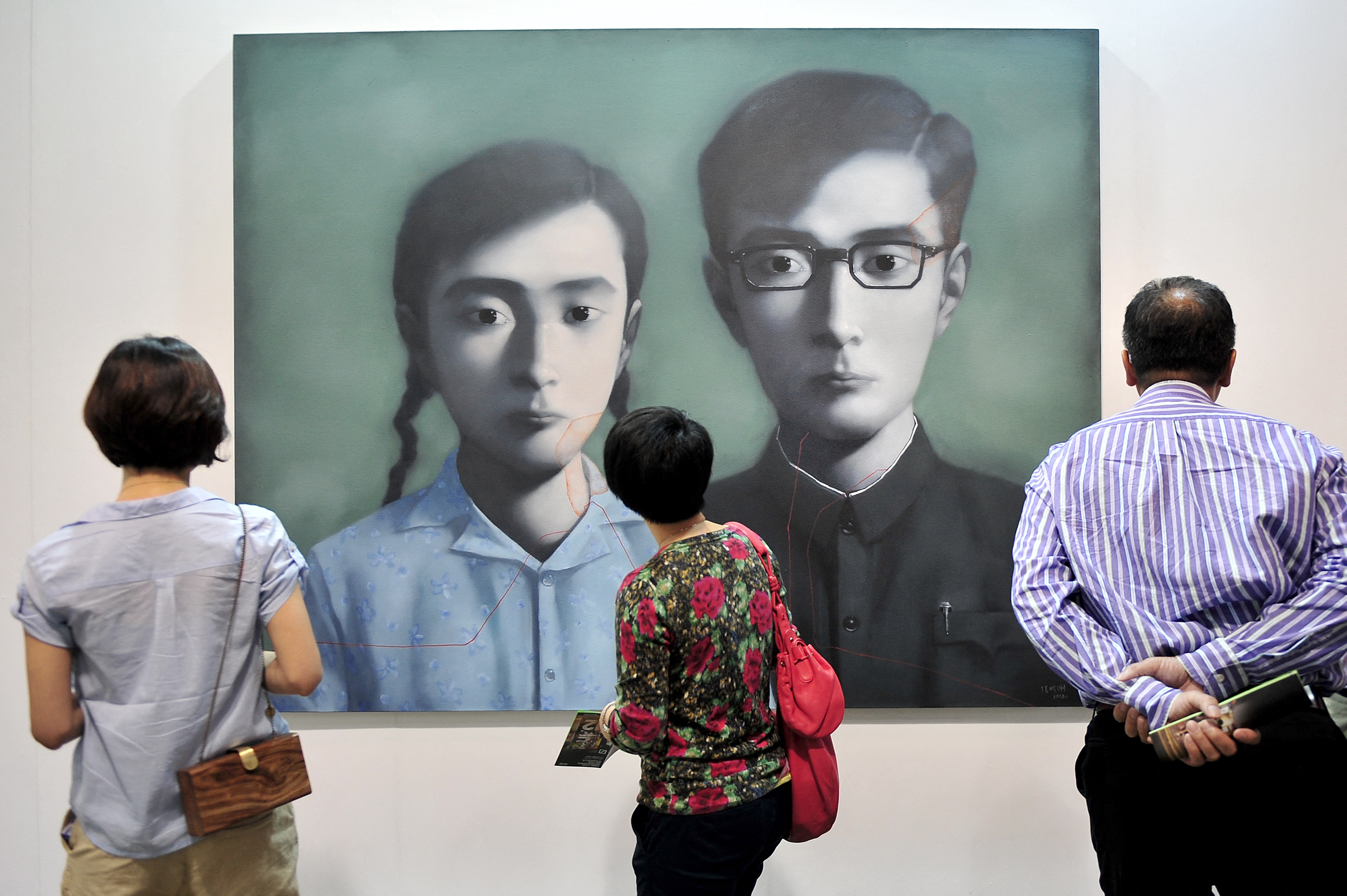 張曉剛的創作企圖「呈現假的照片」，暗示隱藏在一張張照相館千篇一律的照片中，人們深受壓抑的心理狀態。他說：「在中國，有一個時期，每一個家庭看起來都一樣。」圖為張曉剛〈血緣：兄妹〉，2012年5月16日香港國際藝術博覽會。（Philippe Lopez / AFP）