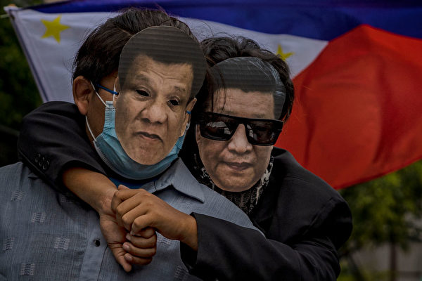 6月12日，菲律賓民眾戴著習近平和菲律賓總統杜特蒂的面具，在中共駐馬尼拉使館前抗議中共強佔菲律賓水域。（Ezra Acayan/Getty Images）