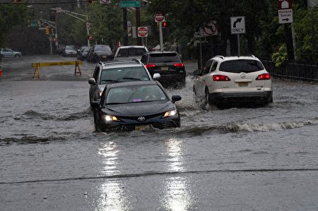热带风暴亨利带来降雨，8月22日新泽西州Hoboken的街道被淹没，汽车涉水而过。