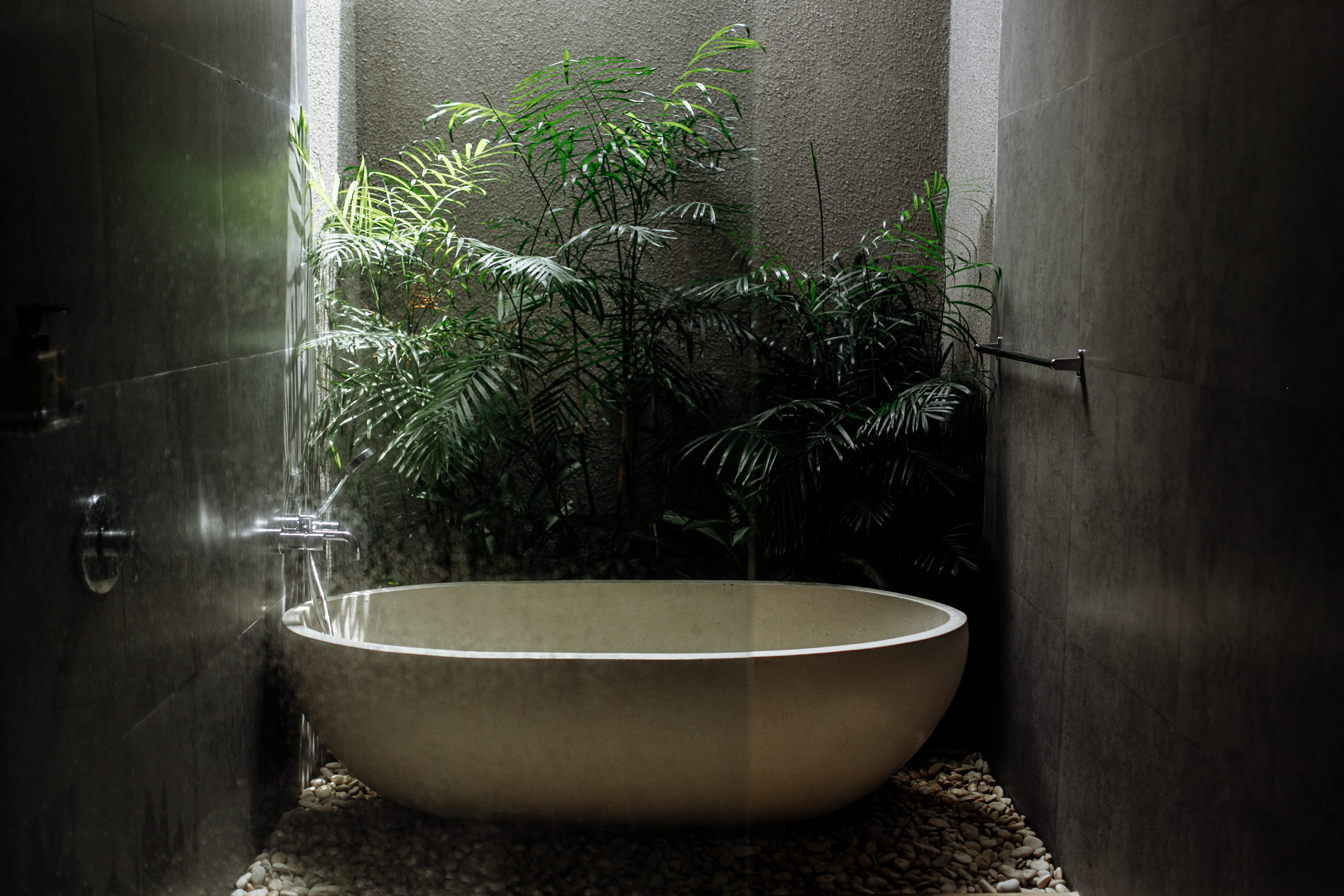 室內浴室加上熱帶植物、卵石與採光中庭，彷彿置身大自然。（Shutterstock）