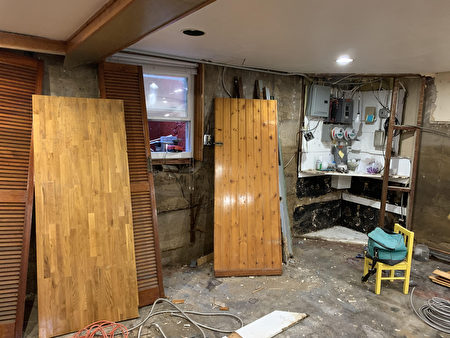 皇后区一家华人正在家中清理和装修被洪水泡坏的地下室，所有木板都被泡坏发霉，需要重新更换。