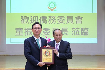 侨委会委员长童振源向台湾会馆理事长苏春槐回赠“百彦汇聚”奖牌。