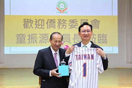 台湾会馆理事长苏春槐向侨委会委员长童振源致赠代表纽约的水晶苹果，以及纽约大都会台湾日的“Taiwan No.1”球衣。