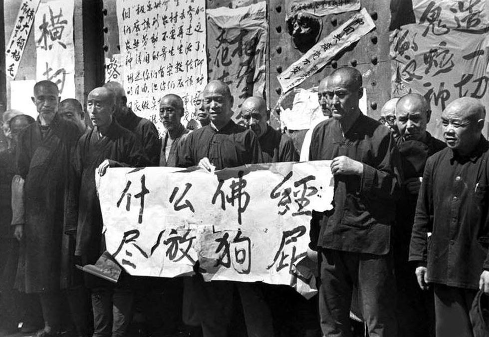 文化大革命時間,紅衛兵逼迫僧人手拿「什麼佛經 盡放狗屁」標語在寺院前示眾。(網路圖片)