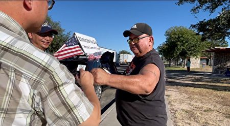 在德州Fort Stockton的公路上，皮卡司机Mario Delgedo对车队义工表示支持。