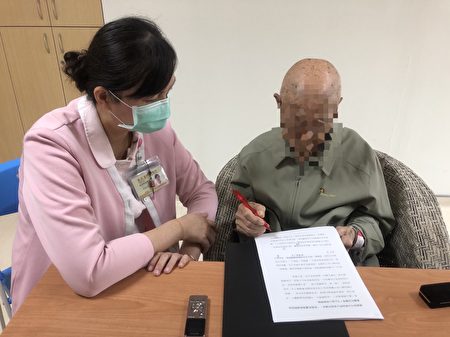 慈心病房护理师(左)协助与单身荣民吴爷爷(右)核对“生命之书”初稿。