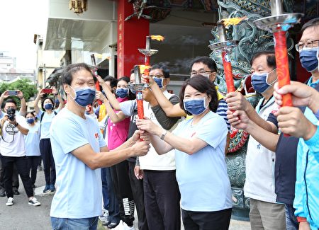  由市长黄敏惠引燃圣火传递给玉山国中校长郑振铭(左)。