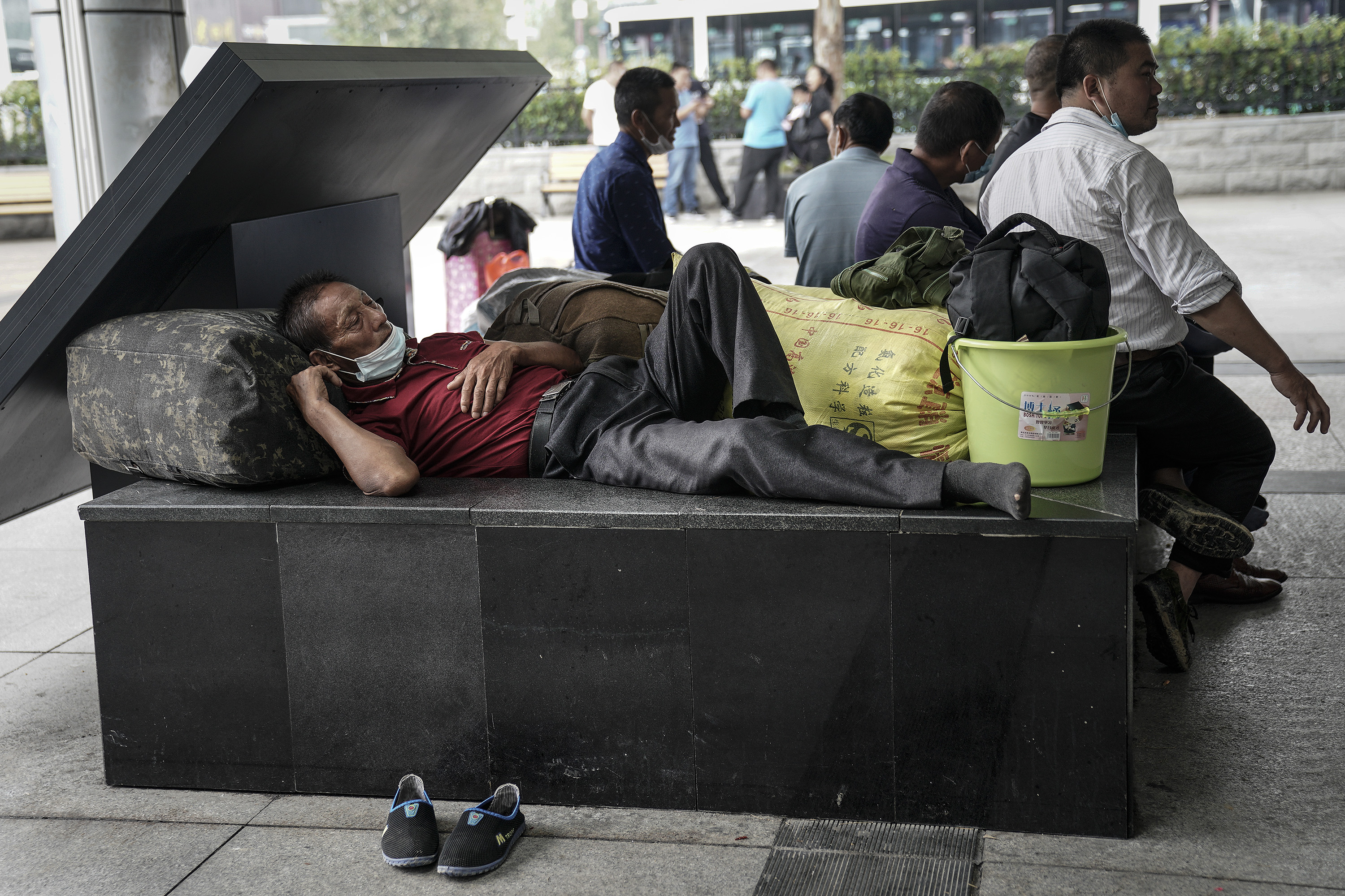 据统计，到2020年底，全中国的农民工总数约有2.856亿人，占总人口的五分之一。图为2020年9月16日，中国湖北省武汉市，农民工戴着口罩躺在汉口火车站外的台阶上。（Getty Images）